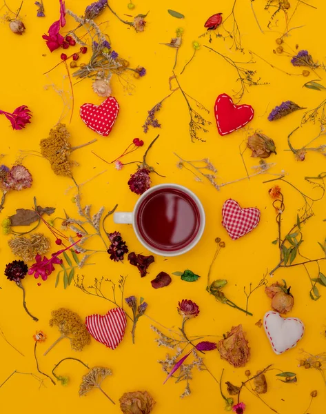 Chávena branca de chá vermelho com formas de coração e ervas — Fotografia de Stock