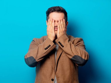 Mavi arka planda baş ağrısı olan bir adam. 