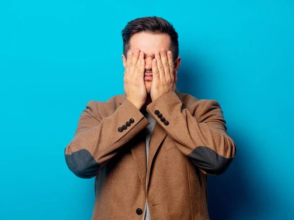 Homem com dor de cabeça no fundo azul — Fotografia de Stock