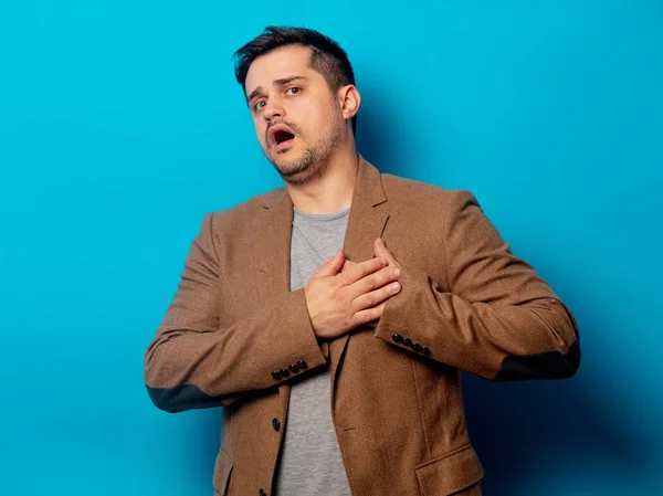 Uomo con il cuore malato su sfondo blu — Foto Stock