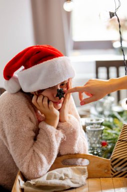 Annesi Noel yemeğinde kızının burnuna fiyonk takıyor.