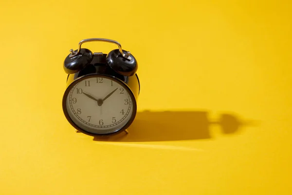 Relógio despertador com dois sinos no fundo amarelo — Fotografia de Stock