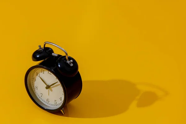 Reloj despertador con dos campanas sobre fondo amarillo — Foto de Stock