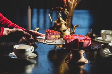 Kadın çay partisinde pasta tutuyor.