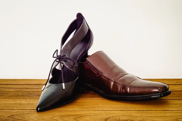 Adam ayakkabı ve kadın siyah yüksek topuklu ayakkabılarla kahverengi ahşap backg — Stok fotoğraf