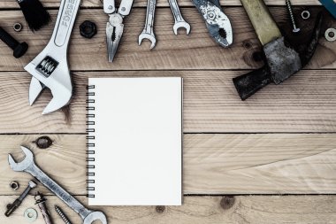 Boş kağıt defter ile kullanışlı araçlar üzerinde ahşap arka plan damla