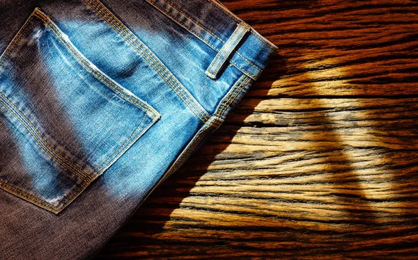 Jeans blu su sfondo di legno, Vista dall'alto con spazio copia — Foto Stock