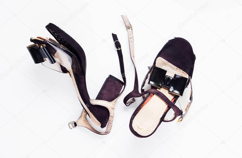 Female broken high heel shoes on white background