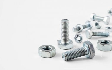 Beyaz backgro üzerinde çeşitli metal çelik somun ve civata Close-Up