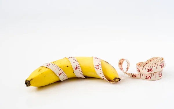 Dieta conceito saudável. Banana com fita métrica no backgr branco — Fotografia de Stock