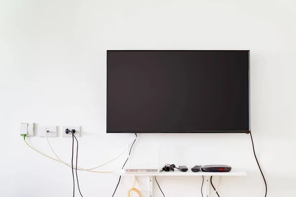 Lcd tv on wall with remote, wireless internet access point and s — Stock Photo, Image