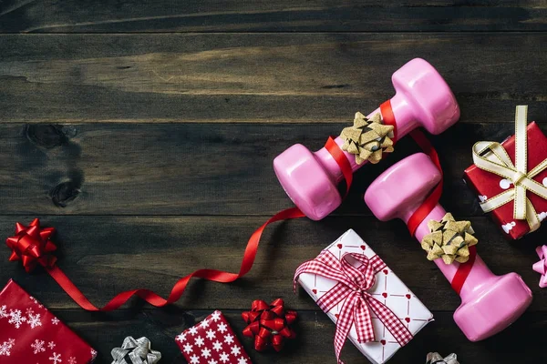 Pembe spor dambıl, hediyeler ve ahşap arka plan, Merr'e üzerinde yay