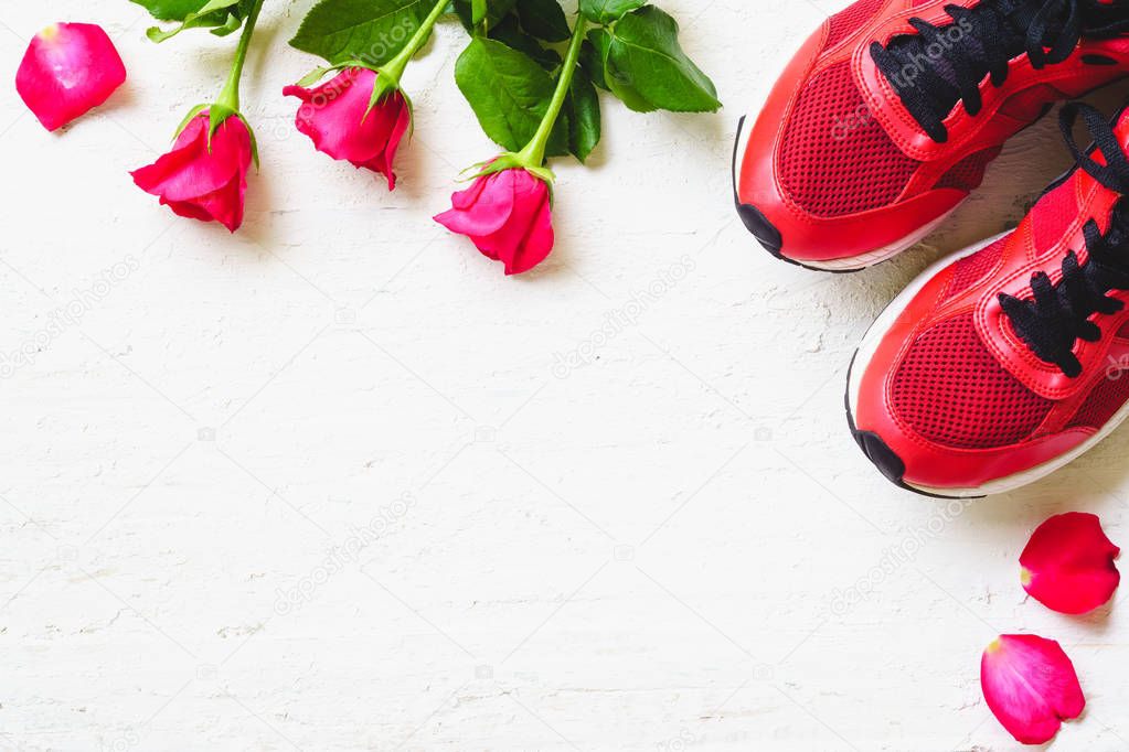 Red sport shoes  and red roses on white wooden background, Valen