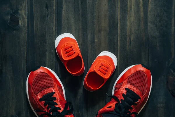 Two red sport running shoes or sneakers of mother or father and