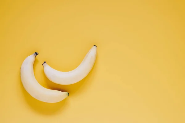 Two ripe sweet testy bananas on yellow background top view with — Stock Photo, Image