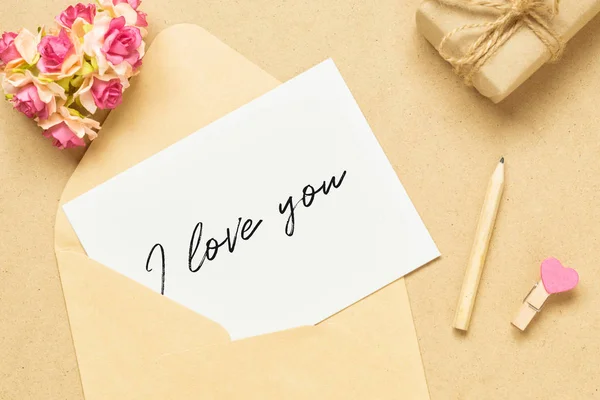 用"我爱你"的文字和文字在手工木料上贴上调校信和信封。 — 图库照片