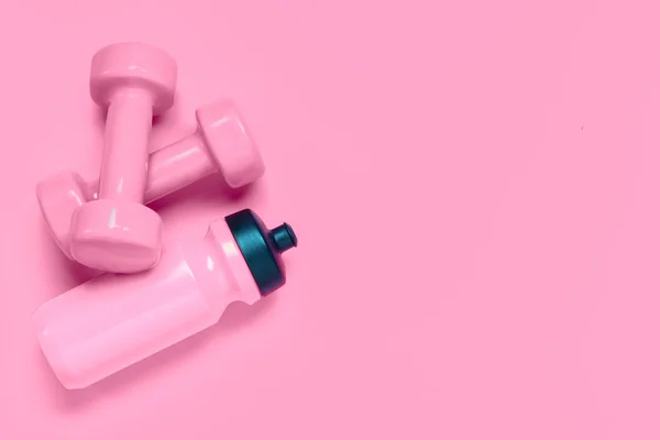 Fitness edzés háttér koncepció rózsaszín súlyzók és palack — Stock Fotó