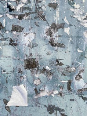 Abstract background of  grunge dirty wall. Traces of papers were torn from a rusty light blue metal wall.