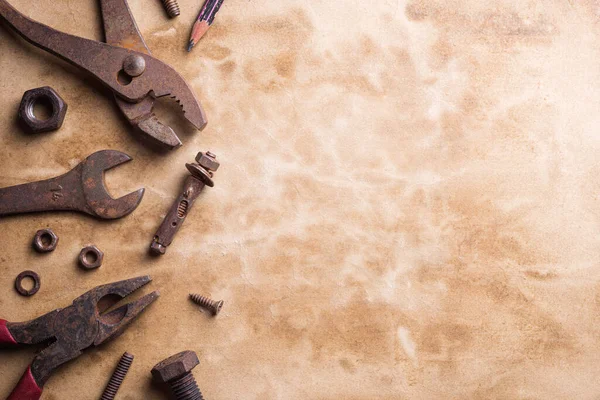 Variation of old rusty handy tools on grunge background. Pliers, bolts and nuts, screw and other industrial equipment. Flat lay top view  with copy space.