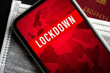 Coronavirus ya da Covid-19 salgın tecrit arka planı konsepti. Kırmızı pasaporttaki gri maskeli sahte cep telefonu. Siyah masanın üzerinde kopya alanı olan düz bir görünüm yatıyordu.
