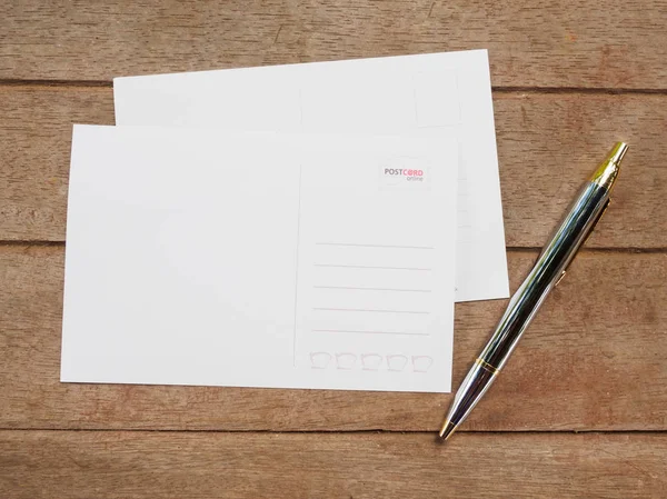 Ovanifrån blank baksida vykort med penna på trä bakgrund — Stockfoto