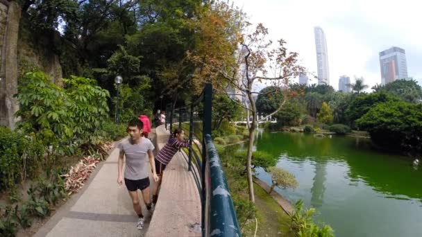 Несколько человек прогуливаются по парку Коулун (временной промежуток) ) — стоковое видео