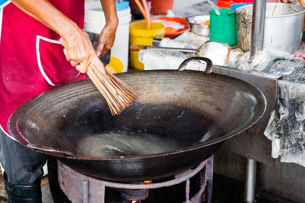 Člověk čistí wok na Kimberly Street Food Night Market — Stock fotografie