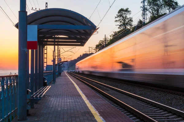 Plataforma de estação ferroviária e trem em movimento desfoque — Fotografia de Stock