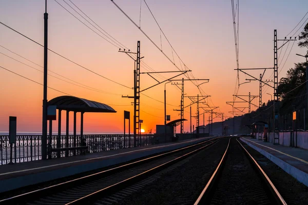 Plataforma de estação ferroviária e ferrovia no crepúsculo — Fotografia de Stock