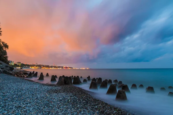 Pedras de concreto no mar no fundo da costa — Fotografia de Stock