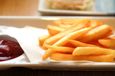 Masanın üzerinde beyaz bir tabak kızarmış patates kapatın