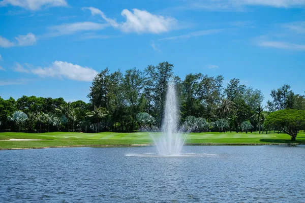 Liggande dammen med en fontän och breda gräsmattor, golfbanor. — Stockfoto