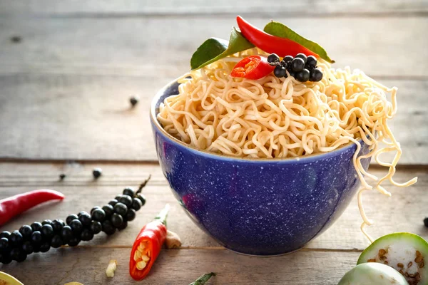Instant noodles in a bowl with chili pepper and lime leaves — Stock Photo, Image