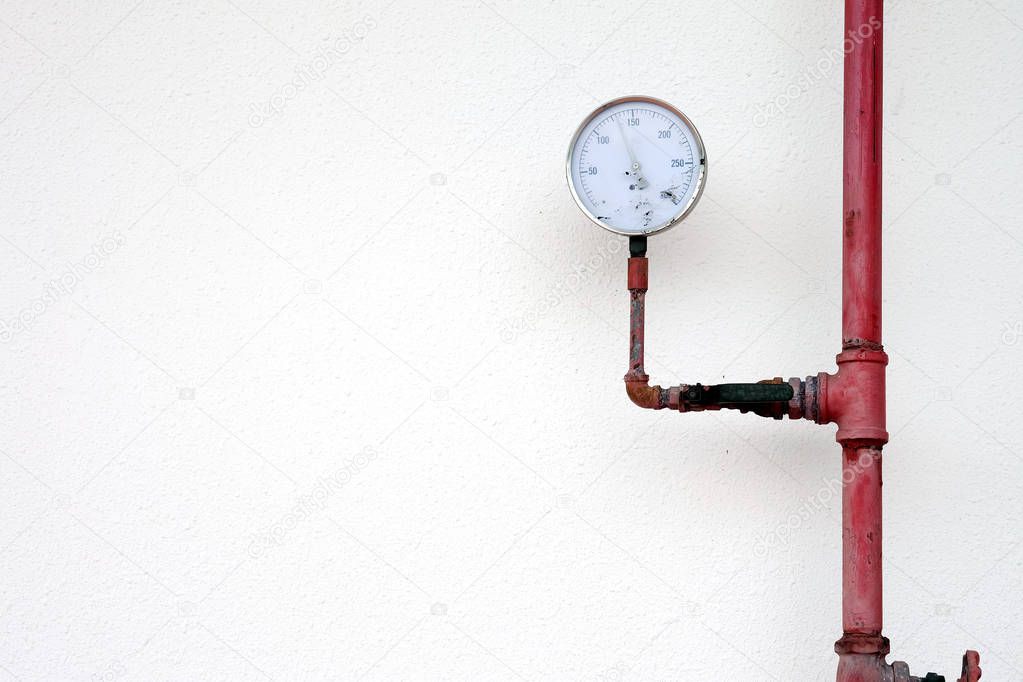 Pressure gauge and water pipe valve water on white wall