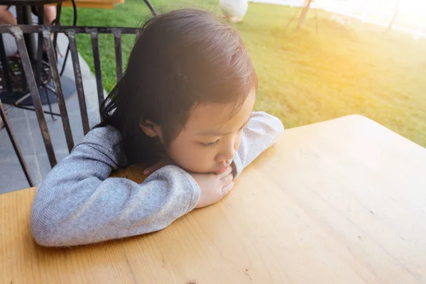 Asiatisches Mädchen, das allein an einem Tisch sitzt, emotional traurig und einsam — Stockfoto