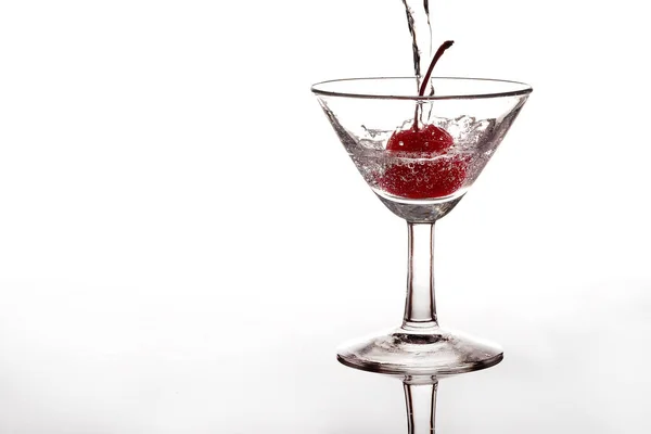 Verser de l'eau gazeuse ou du soda dans un verre avec une cerise — Photo