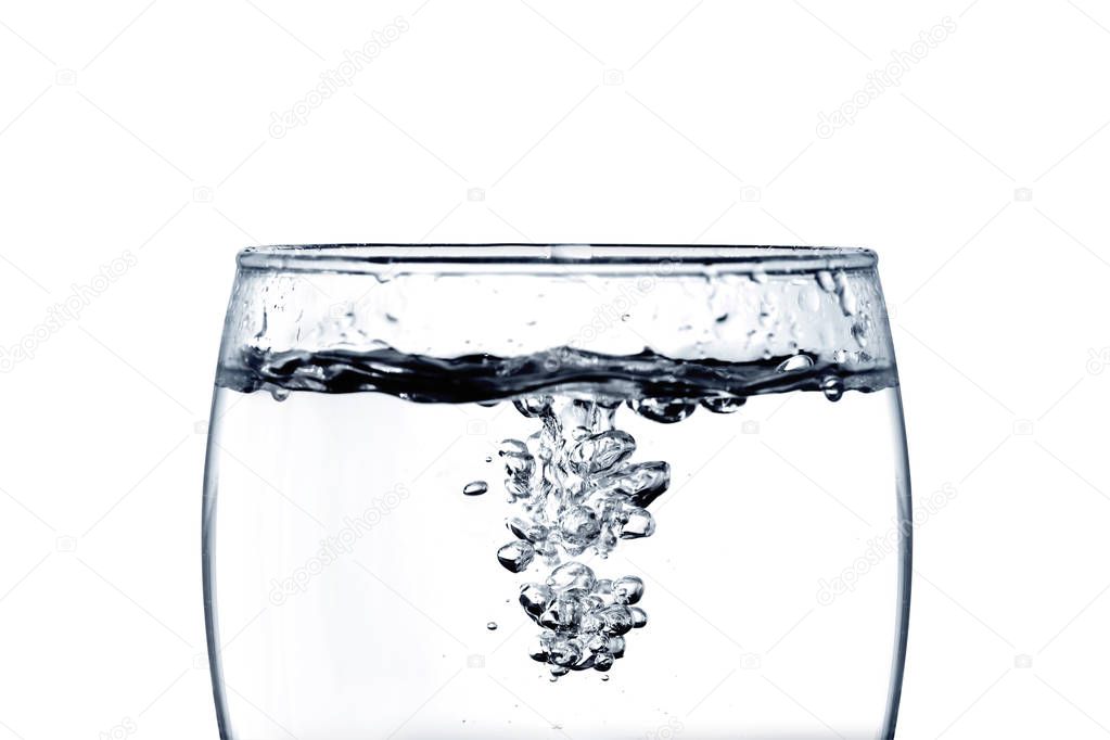 pouring water into a glass closeup isoleted on white background