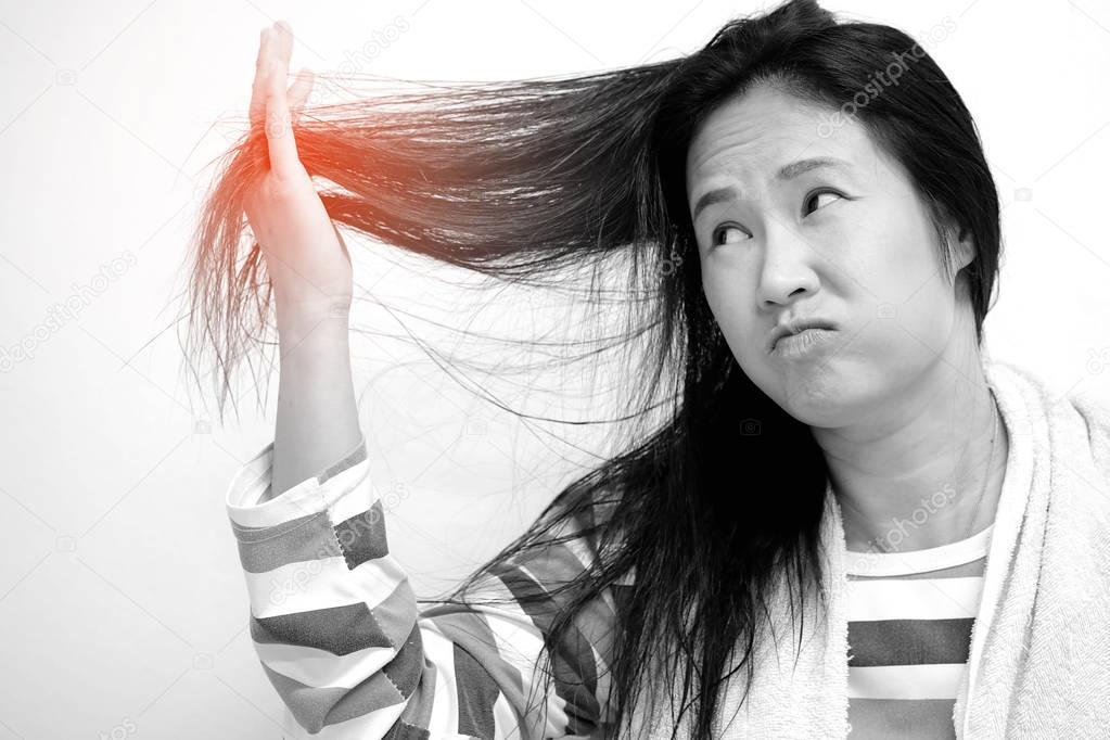 Asian women are looking damaged hair in her hand