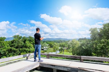 Erkek turistler bir manzara parlak gökyüzü ile seyahate üzerinde notlar alıyor