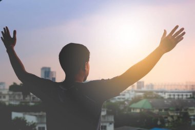 Bir adam silüeti kazanan veya manzara arka plan üzerinde özgürlük olarak kollarını geniş yayılmış.