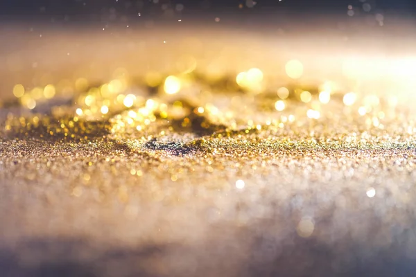 Sprinkle gold dust on a black background with copy space