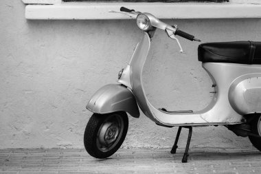 Bangkok, Tayland - 18 Aralık 2016: Siyah beyaz duvar sesi yanındaki eski klasik retro Vespa motosiklet Park