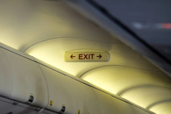 Emergency exit sign mounted above the head in the aircraft cabin