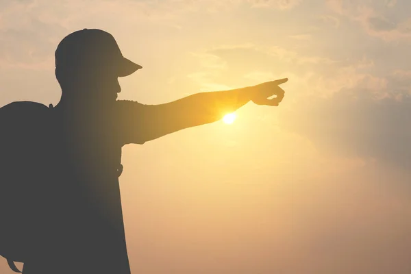 Silhouette Eines Touristenmannes Mit Hut Und Umhängetasche Zeigt Nach Vorne — Stockfoto