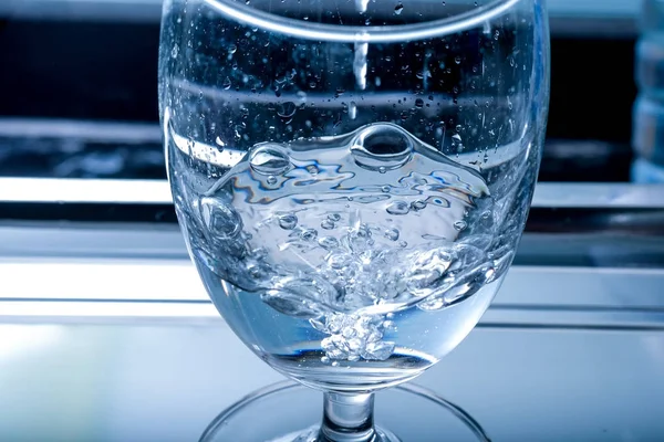 pouring water into a glass closeup