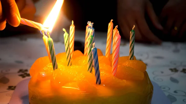 Mãos São Velas Acesas Bolo Para Comemorar Aniversário Laranja — Fotografia de Stock