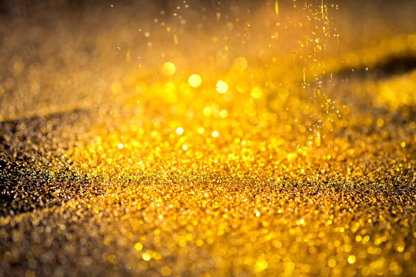 Блестящая золотая пыль на чёрном фоне с пространством для копирования
