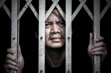 Asyalı erkek çelik kafeste sıkışıp kalırlar ve yüzleri üzgün dikkat et.