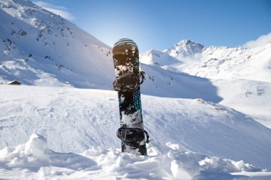 Güneşli bir günde dağlarda snowboard