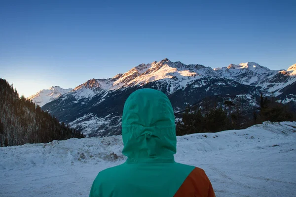Žena v horách, stál a pozoroval krásné hory, zimní krajina v západu slunce — Stock fotografie